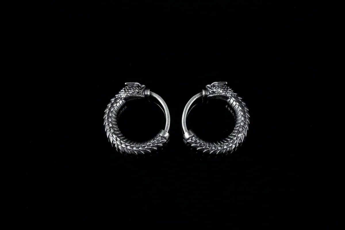 A pair of textured silver hoop earrings on black