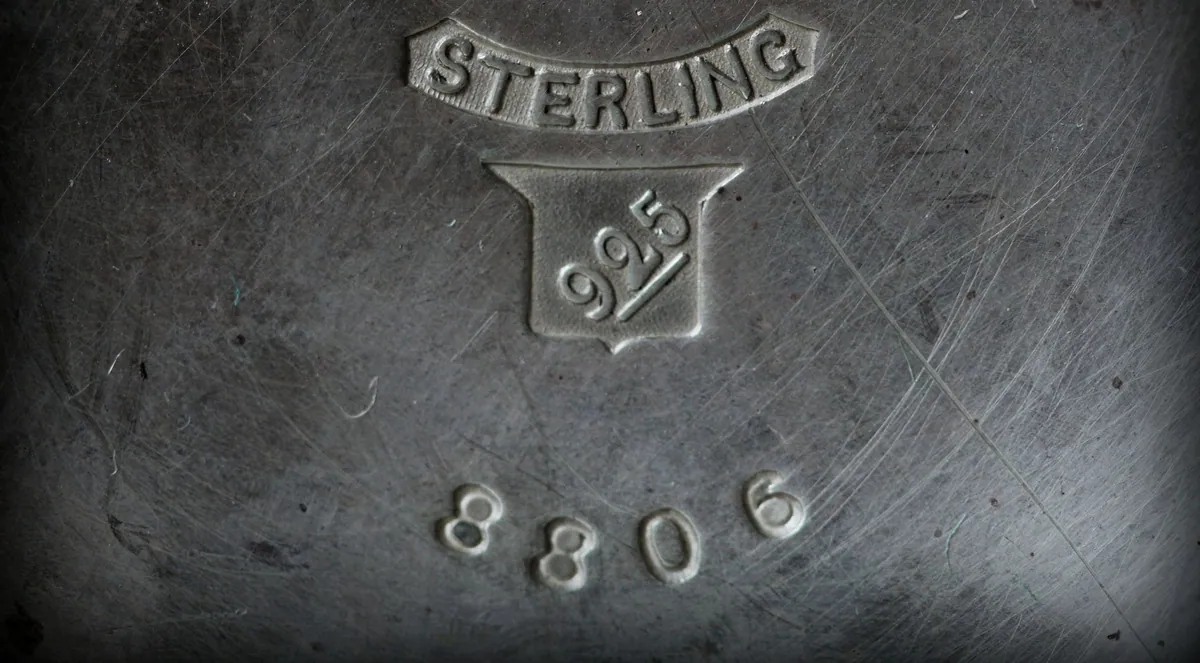 A worn silver surface stamped Sterling and 925 in a small shield