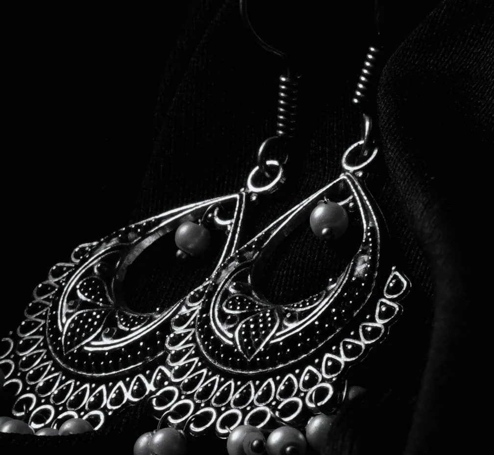 Close view of the silver teardrops, their dotted filigree and small silver beads