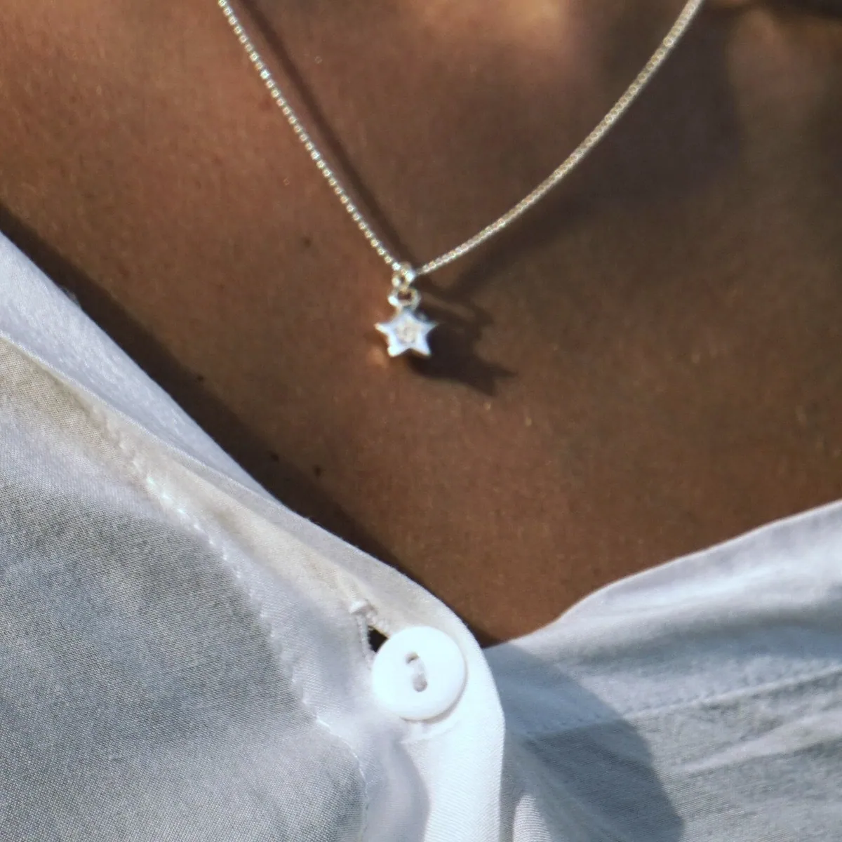 Close view of the small silver star resting just below the collarbone