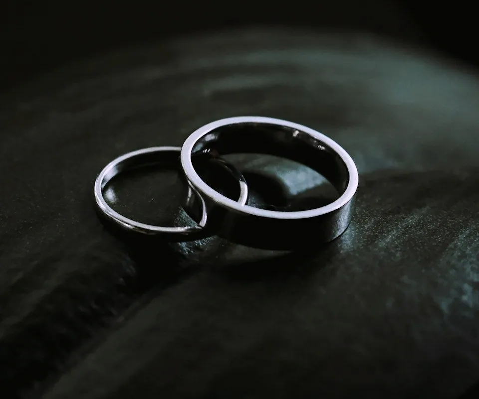 Close view of the two plain silver bands, their rounded edges catching the light